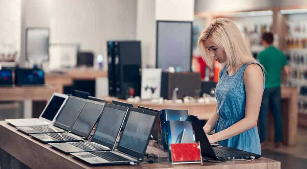 a woman standing in front of several laptops